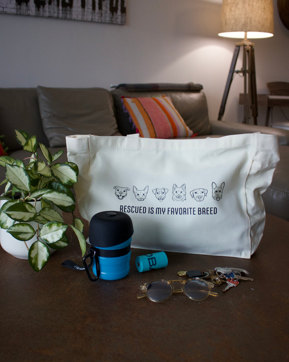 Light canvas tote bag with dog-face print and 'Rescued is my Favorite Breed'