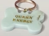 Small mint resin bone-shaped dog tag with a gold-tone ring and decorative charm